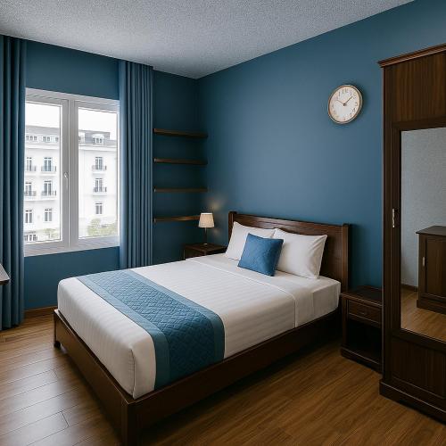 a bedroom with a bed with blue walls and a clock at Tuan Thuy Hotel in Da Lat