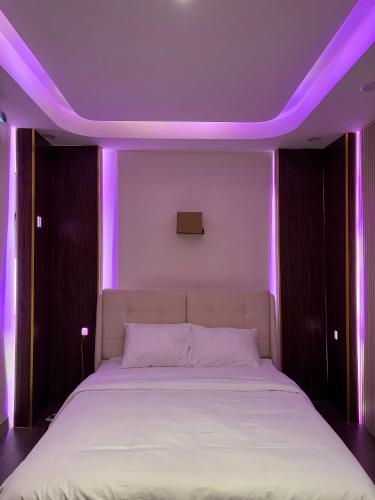 a bedroom with a bed with purple lights on it at Star Night Hotel and Apartment in Hanoi