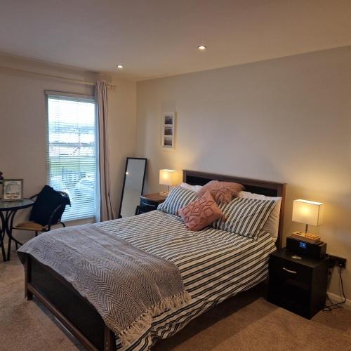 a bedroom with a bed with two pillows and a window at Beach View Ballycastle Escape in Ballycastle