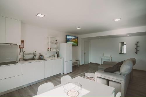 a kitchen and living room with a couch and a table at CasaMaeDouro in Peso da Régua