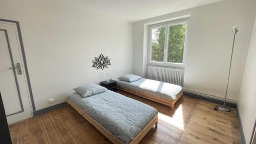 ein Schlafzimmer mit zwei Betten und einem Fenster in der Unterkunft Gite Chez Krol in Bonnes