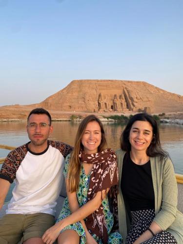 a group of three people sitting next to a body of water at Amon guest house in Abu Simbel
