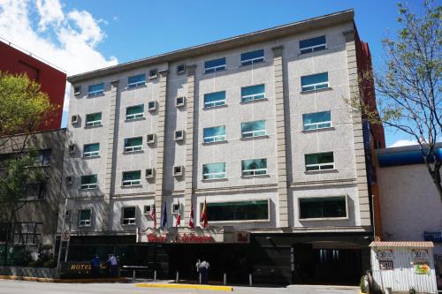 a large gray building with flags in front of it at Hotel Monaco in Mexico City
