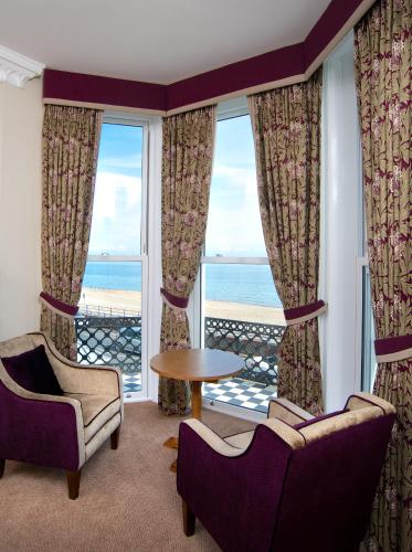 a living room with a view of the ocean at Langham Hotel Eastbourne in Eastbourne