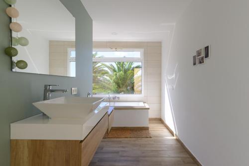 a bathroom with a large sink and a window at Chalet Sol y Beach in San Agustin