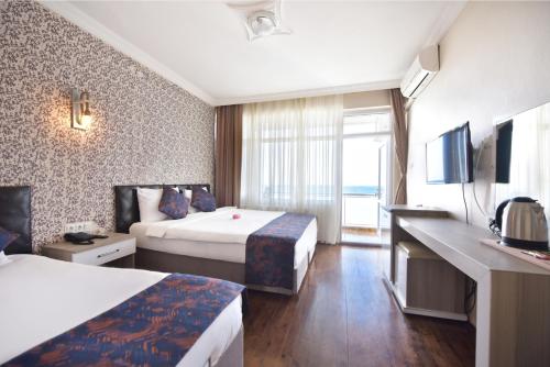 a hotel room with two beds and a television at Inebolu Gardenya Hotel in Inebolu