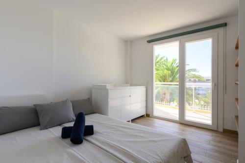 a white bedroom with a large bed and a large window at Chalet Sol y Beach in San Agustin