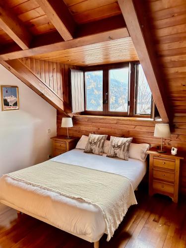a bedroom with a bed in a room with windows at El Mirador d'Olp in Olp
