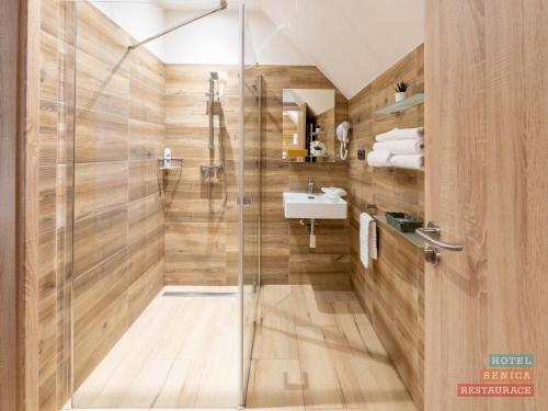 a bathroom with a shower and a sink at Hotel Benica in Benešov