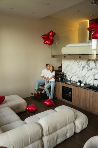 a man and a woman sitting in a living room at SkySpa Apartments - апартаменти з джакузі на терасі з видом на Печерськ in Kyiv