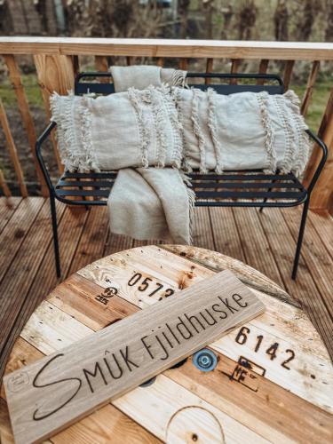 a wooden cutting board and pillows on a deck at Smûk Fjildhuske in Echtenerbrug