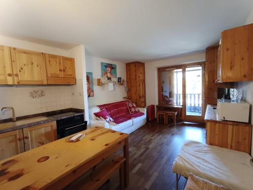 une cuisine et un salon avec un canapé et une table dans l'établissement Studio 4 pers avec terrasse et jardin, parking couvert, à Montgenèvre - FR-1-445-173, à Montgenèvre