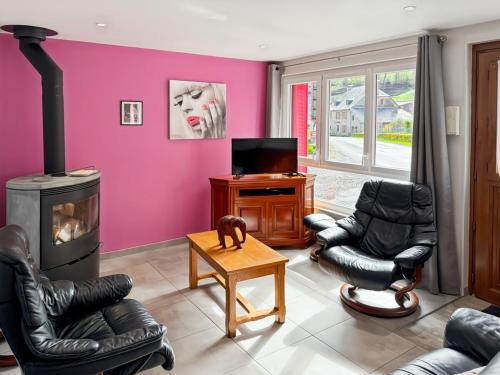 ein Wohnzimmer mit zwei Stühlen und einem Kamin in der Unterkunft Vallée de la Jordanne, Maison cosy 6pers, terrasse in Saint-Julien-de-Jordanne