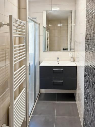 une salle de bain avec un lavabo et un miroir dans l'établissement Vallée de la Jordanne, Maison cosy 6pers, terrasse, à Saint-Julien-de-Jordanne