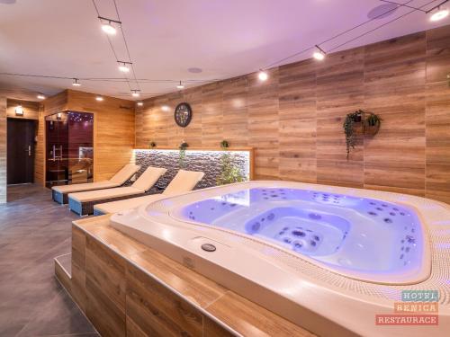 jacuzzi en una habitación con paredes de madera en Hotel Benica, en Benešov