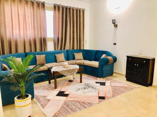 a living room with a blue couch and a table at joy house in Luxor