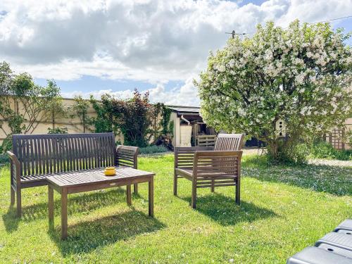 due panche e un tavolo nell'erba di Country House with swimming pool a Épeautrolles