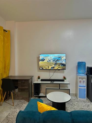 a living room with a blue couch and a table at Koki Bnbs Kamakis in Ruiru