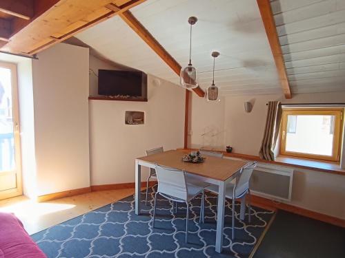 une salle à manger avec une table et des chaises dans l'établissement Appartement cosy, 100m des pistes et commerces, 4 pers, 30m², Parking, Balcon plein sud - FR-1-445-202, à Montgenèvre