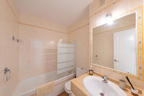 Un baño con lavabo, inodoro y espejo. en Aloe Pasito, en La Isleta del Moro