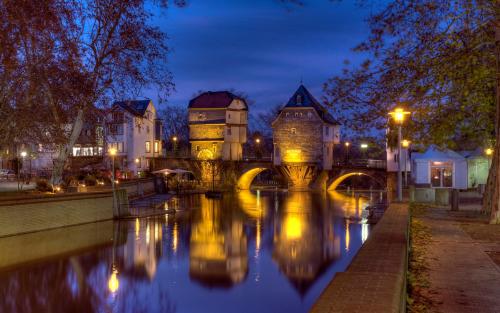 a castle with a bridge over a river at night at Stilvolle, gemütliche und haustierfreundliche Wohnung in Hackenheim