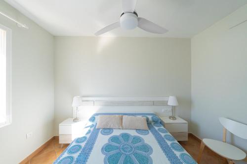 Un dormitorio con una cama y un ventilador de techo. en Aloe Pasito, en La Isleta del Moro