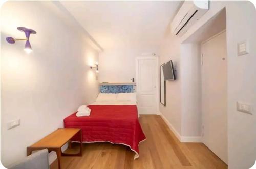 mały pokój z łóżkiem z czerwonym kocem w obiekcie Galluppi Studio Flat By HouseinNaples w mieście Neapol
