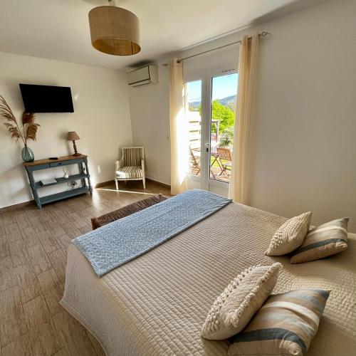 - une chambre avec un grand lit et une porte coulissante en verre dans l'établissement Casa Eva Maria, à Patrimonio