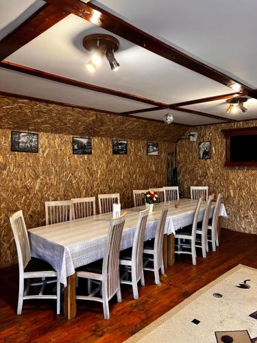 a dining room with a long table and chairs at Casa de vacanță Trei Zâne in Sovata