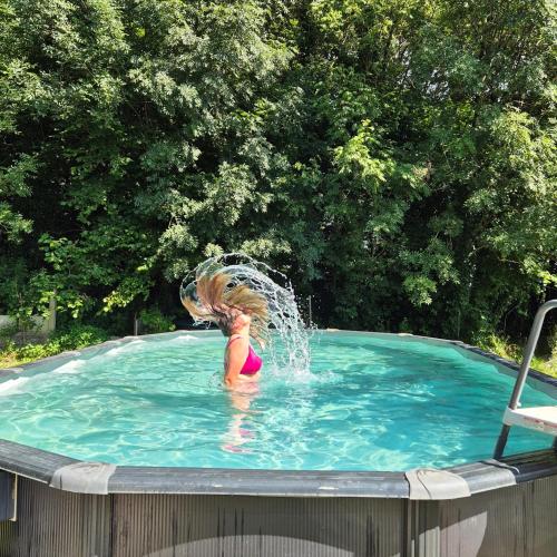 une femme dans une piscine avec ses cheveux dans l'eau dans l'établissement YURT in beautiful nature with a lot of privacy, à Troche