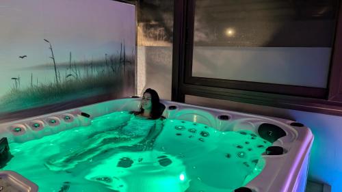 a bath tub filled with green water next to a window at Casa Jesús Turismo Rural in Lires