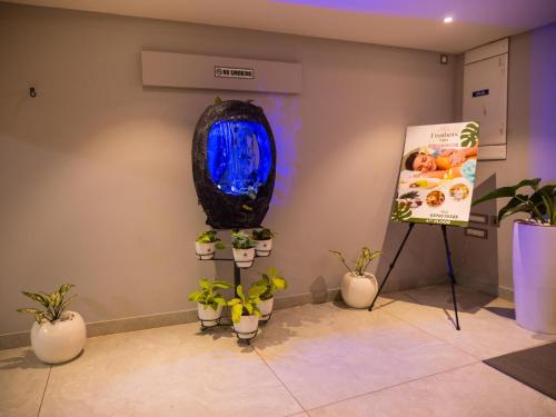 a room with potted plants and a sign on the wall at Hotel Grand Sudhan in Thanjāvūr