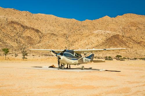 a small plane parked in the desert at Barkhan Dune Retreat in Solitaire