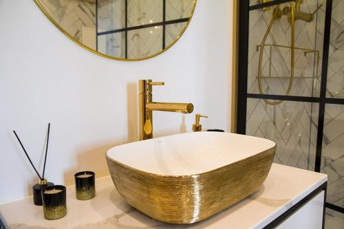 a bathroom with a gold sink and a mirror at Widok na Starówkę Mona Lisa by Rentoom in Toruń