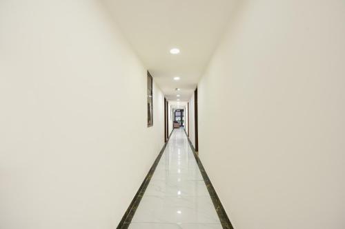 an empty corridor of a white building with a long hallway at FabExpress Under Bridge - Near Nizamuddin Railway Station in New Delhi