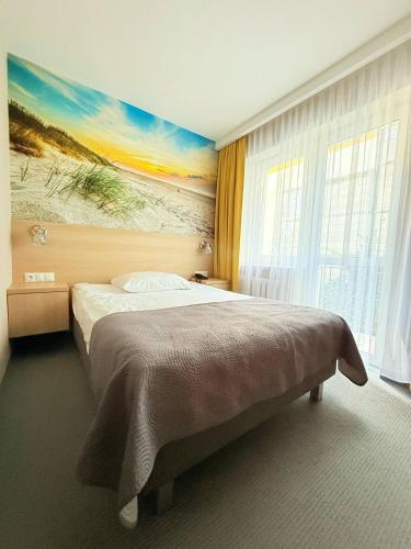 a bedroom with a bed with a painting on the wall at Hotel La Siesta & Medical Spa in Jastrzębia Góra
