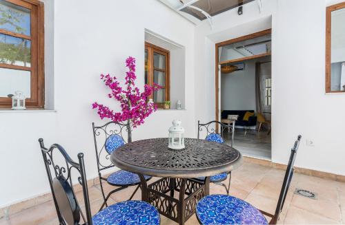 a table with chairs and a vase with purple flowers at Catedral Moderno Centro in Jerez de la Frontera