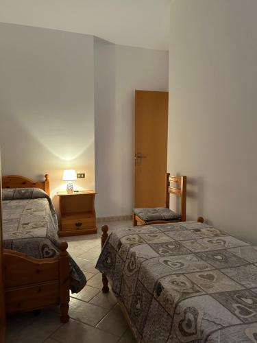 a bedroom with two beds and a table and a chair at Agriturismo Bellavista in Ronzano