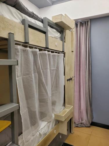 Camera con letto e tende bianche. di Wander Luxe a Tirana