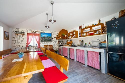 a kitchen with a wooden table with chairs and a counter at Vila Veronika 2 in Pula