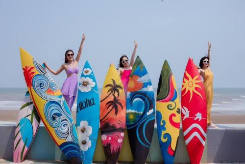four women are standing in front of their surfboards at Flamingo Hai Tien in Nam Khê