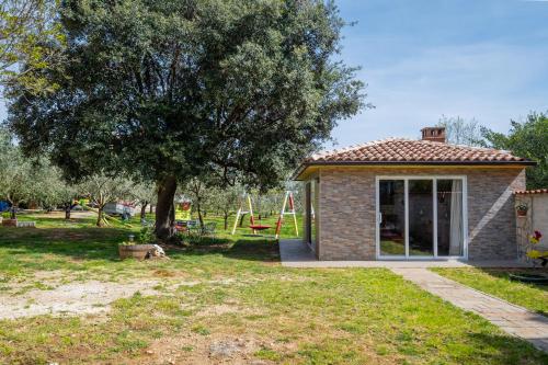 a small house with a tree and a playground at Vila Veronika 2 in Pula