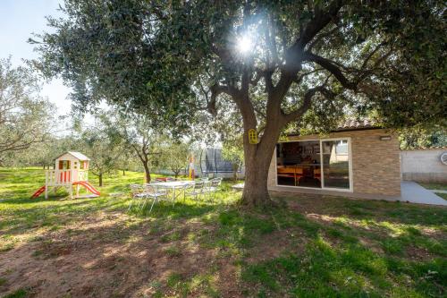 a house with a tree and a playground at Vila Veronika 2 in Pula