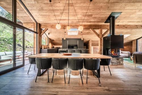 une cuisine et une salle à manger avec une grande table et des chaises en bois dans l'établissement Chalet Jolimont Châtel - by EMERALD STAY, à Châtel