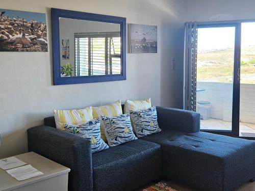a blue couch with pillows in a living room at MADRIKO 36 Cozy self catering 2 bedroom apartment in Langebaan