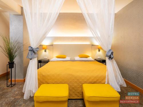 a bedroom with a yellow bed with two yellow chairs at Hotel Benica in Benešov