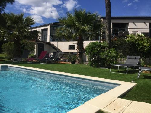 a swimming pool in front of a house at L'ESCALE COTE BLEUE B&B AND Spa in Sausset-les-Pins