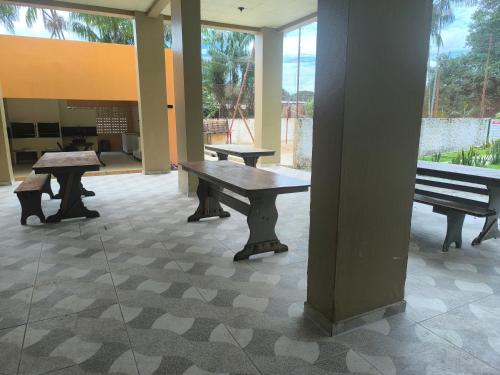 three benches sitting in a room with windows at Apartamento mobiliado Praia do Farol in Belém