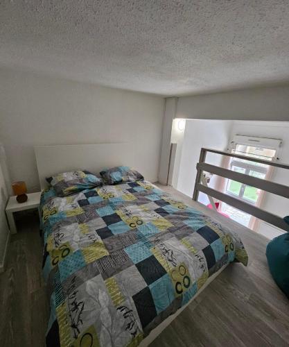 une chambre avec un lit avec une couette dessus dans l'établissement Résidence des Jasmins, à Metz