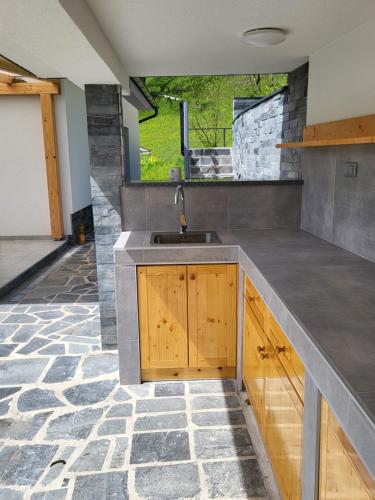 a kitchen with a sink and a stone floor at Holiday home Baron in Radeče